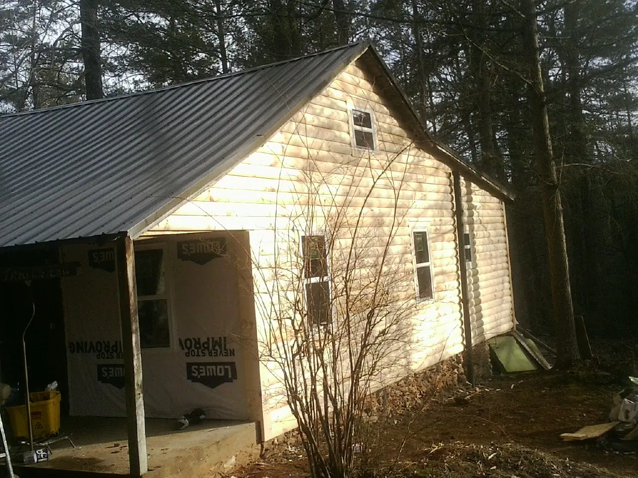 Log siding gable end under a dark metal roof edge in Metropolis