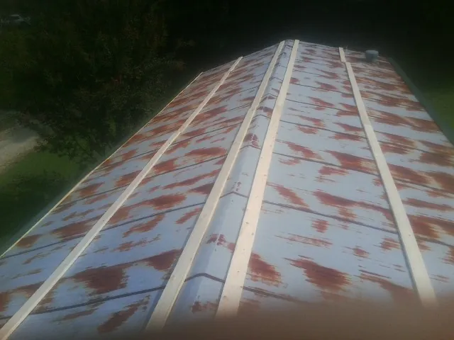 Rusted metal roof panels with new wood purlins before replacement — Storm Damage Roof Repair in Metropolis by Roofing Brothers