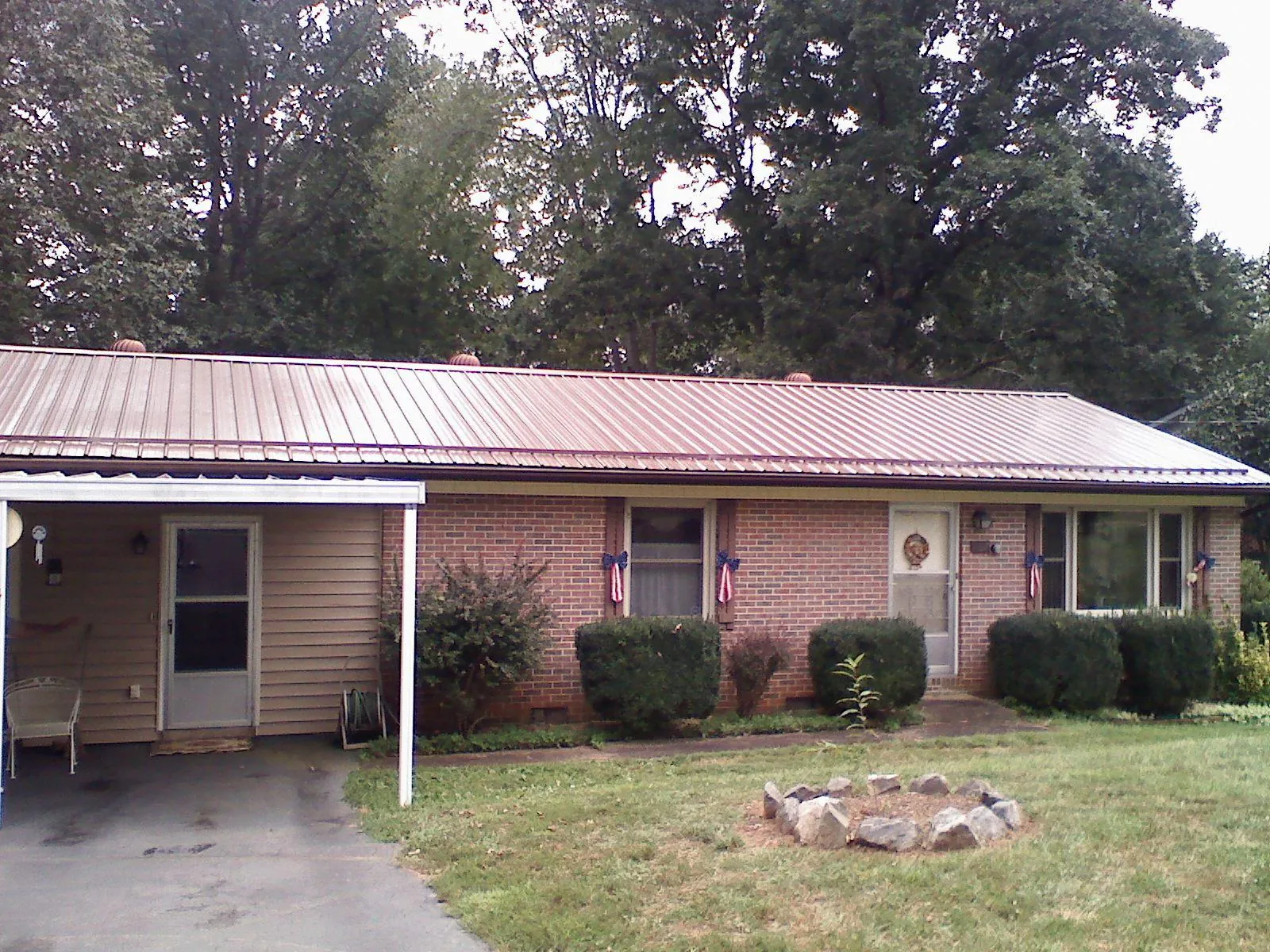 Bronze metal roof and carport on a brick ranch home — Roof Repair work by our crew in Metropolis